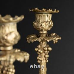 Paire de bougeoirs en bronze dorés, décors au lézard, lions et grappes de raisin